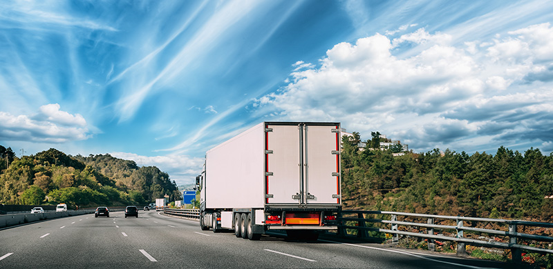 Moving truck driving on a highway under a bright blue sky for Smith & Sons Moving locations
