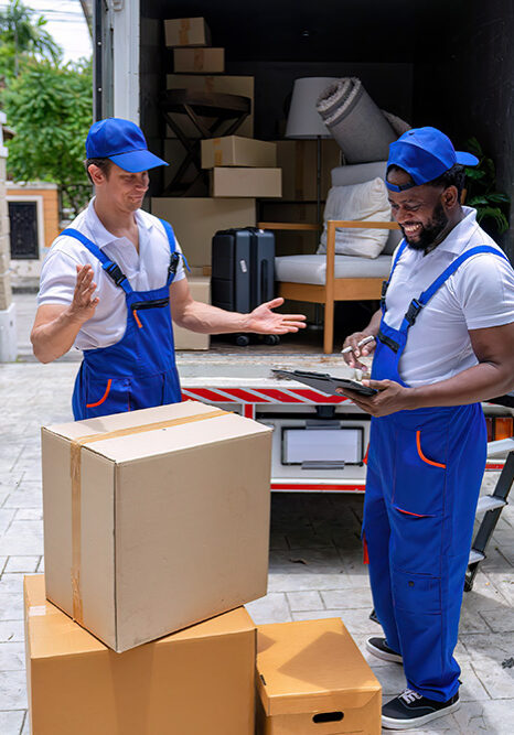 Professional movers reviewing relocation details beside a loaded truck in Birmingham
